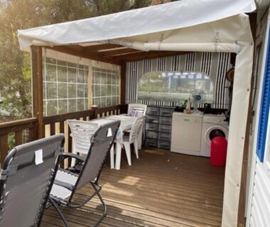 Terrasse couverte avec chaises longues et kitchenette du Mobil Home sans vis a vis