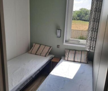 Chambre avec deux lits simples et fenêtre sur campagne dans le Mobil Home tout confort