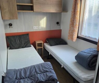 Intérieur chambre avec deux lits simples et rangements dans le Mobil Home tout confort 8 personnes
