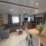 Salon et coin repas dans le Mobil-Home tout confort avec Clim