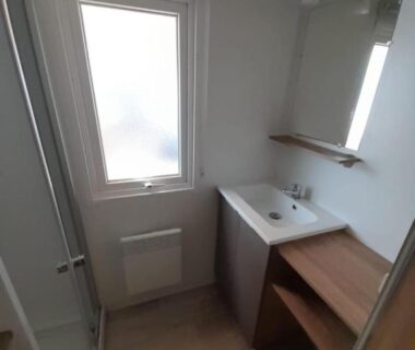 Salle de bains avec lavabo miroir fenêtre et douche du Mobil-Home tout confort avec Clim