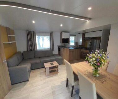 Salon et coin repas dans le Mobil-Home tout confort avec Clim