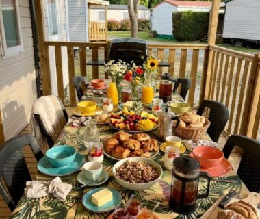 Terrasse couverte avec table de petit déjeuner garnie dans le Mobil-Home tout confort avec Clim