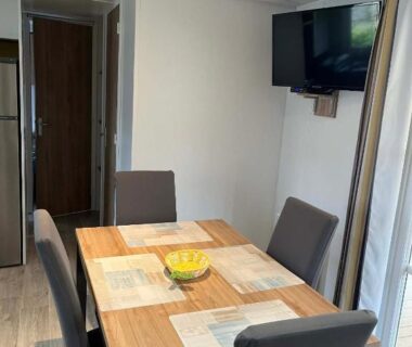 Coin repas avec table et télévision dans le Mobil-Home tout confort avec Clim