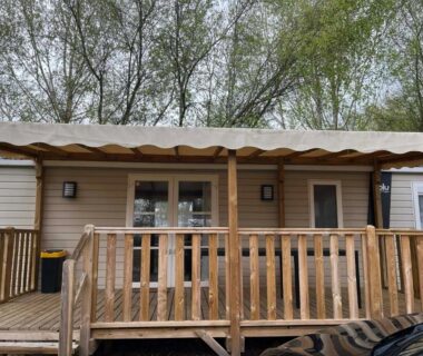 Terrasse en bois avec rambarde et porte vitrée du Mobil-Home tout confort avec Clim
