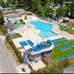 Piscine extérieure avec toboggan et transats au Mobil Home tout confort dans le Domaine de Dugny