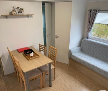 Intérieur coin repas avec table et banquette du Mobil Home Domaine de Dugny