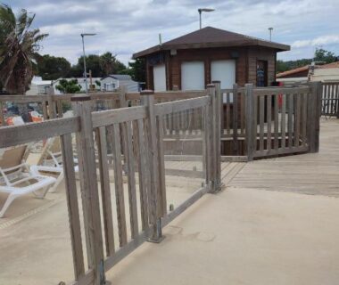 Bord de piscine avec terrasse transats et barrière en bois au mobil home