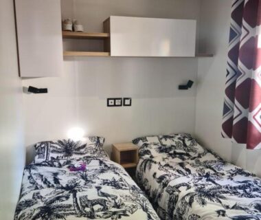 Chambre avec deux lits simples et placards dans le mobil-home