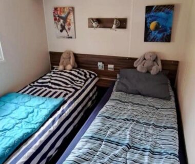 Chambre avec deux lits simples et peluches dans le mobil home