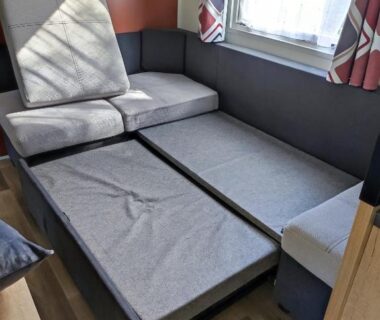 Coin salon avec banquette-lit dépliée dans le mobil home