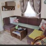 Salon avec banquette coussins et table basse dans le Mobil home