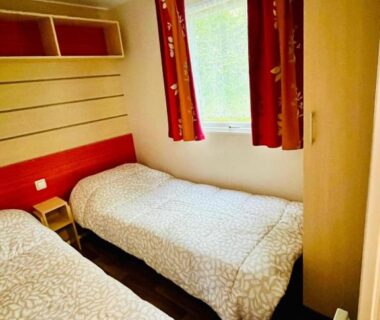 Chambre avec deux lits et fenêtre dans le mobil-home 159 camping Les Clarines