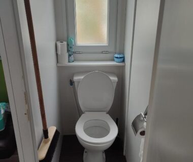WC avec fenêtre et porte-rouleau dans le mobil home Mobil home