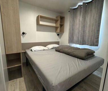 Chambre intérieure avec lit double et rangements dans le mobil-home