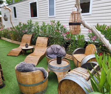 Terrasse extérieure avec chaises longues fauteuils et tonneaux du Mobil-home