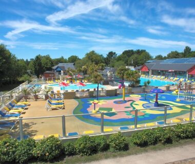Espace aquatique du camping avec pataugeoire et transats au Domaine de Kerlann