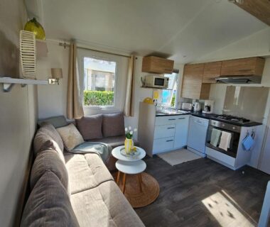 Intérieur avec salon canapé et kitchenette du mobil-home Domaine de Kerlann
