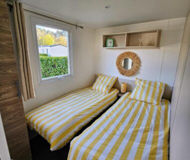 Chambre avec deux lits à rayures jaunes dans le Mobil-home 2 ch 4-6 pers Terrasse et WiFi Domaine de Kerlann