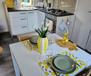 Coin repas avec table dressée et bouquet de tulipes dans le mobil-home du Domaine de Kerlann