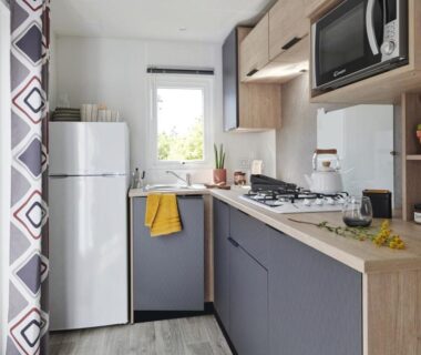 Cuisine équipée avec réfrigérateur et plaque de cuisson dans le mobil-home 2 chambres climatisé du Domaine du Vieux Moulin