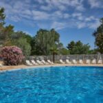 Piscine extérieure entourée de transats et lauriers roses au Mobil-home