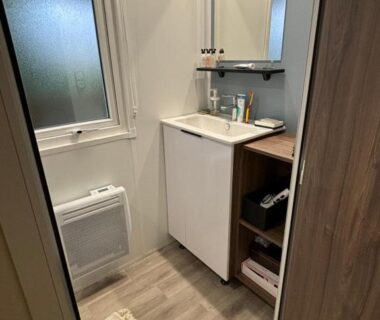 Salle de bains avec lavabo et miroir du mobil home 253 Camping La Réserve