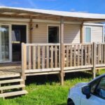 Devant le mobil-home avec terrasse couverte et pelouse du Mobil-home 28 m2, 2 chambres et terrasse