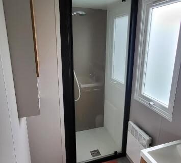 Salle de bain avec cabine de douche et lavabo dans le mobil-home 28 m2 2 chambres et terrasse