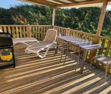 Terrasse en bois avec chaise longue et barbecue du mobil-home 28 m2 2 chambres et terrasse