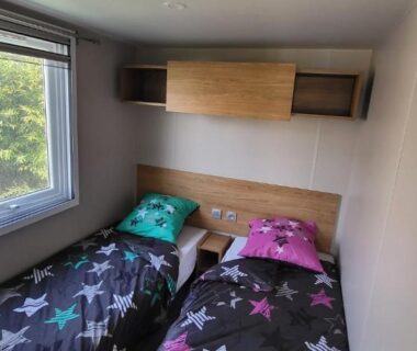 Chambre avec deux lits simples et fenêtre dans le mobil-home 28 m2 2 chambres et terrasse