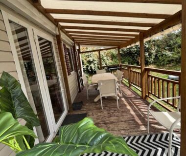 Terrasse en bois avec table chaises et plantes au mobil home 291 camping 4 etoiles Siblu lattes