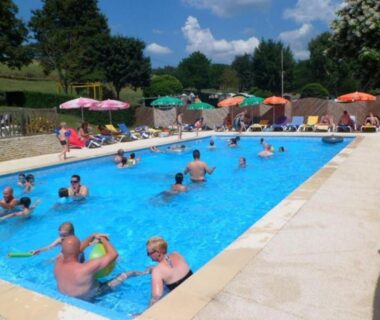 Piscine extérieure avec baigneurs et parasols au Mobil home