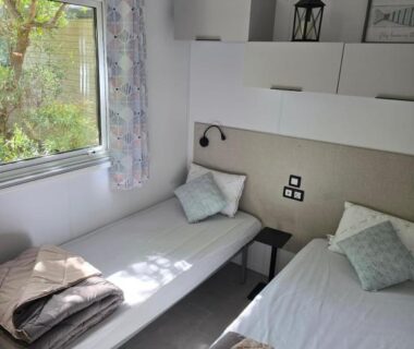 Chambre avec deux lits simples et fenêtre dans le Mobil home 3 ch 6 pers Camping Mayotte