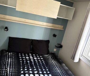 Chambre avec lit double étagères et fenêtre dans le mobil-home 3 ch camping TOHAPI
