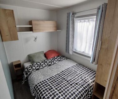 Chambre avec lit double rangements et fenêtre dans le mobil-home 3 chambres