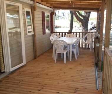 Terrasse couverte en bois avec table et chaises du Mobil home 3 chambres