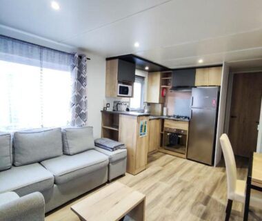 Séjour avec canapé et kitchenette dans le Mobil home 3 chambres Accès direct plage 4 Etoiles