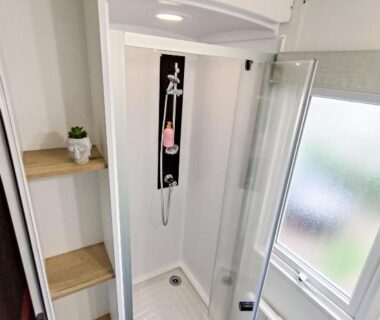 Salle d'eau avec cabine de douche et étagères dans le Mobil home 3 chambres Accès direct plage 4 Etoiles