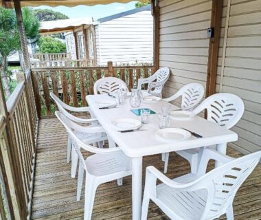 Terrasse couverte en bois avec table et chaises du mobil home 3 chambres Accès direct plage 4 Etoiles