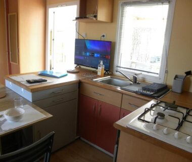 Cuisine équipée avec plan de travail plaques et évier dans le mobil home 3 chambres Sud finistère