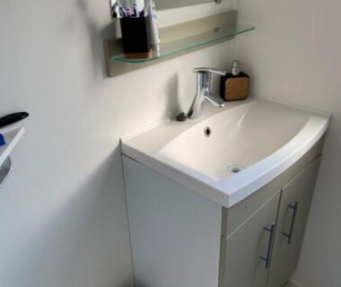 Salle de bain avec lavabo et miroir dans le mobil home 3 chambres au camping Le Grau du Roi