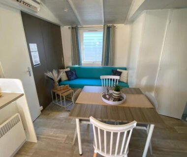 Intérieur coin repas avec table et banquette dans le mobil home 3 chambres du camping Le Grau du Roi