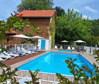 Piscine extérieure avec transats et parasols au Domaine du Vieux Moulin