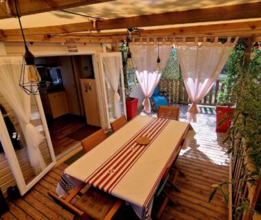 Terrasse couverte avec table et bancs du Mobil-home 3 chambres climatisé sur le domaine 4 étoiles Rivages des Landes