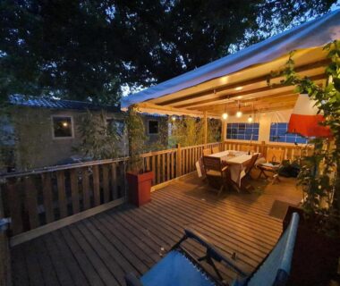 Terrasse en bois éclairée avec table et chaises du Mobil-home 3 chambres climatisé Rivages des Landes