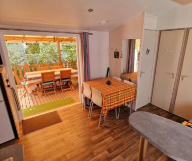 Intérieur et terrasse avec table extérieure du mobil-home 3 chambres climatisé sur le domaine Rivages des Landes