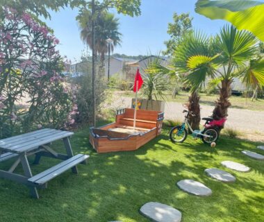 Jardin avec banc bateau en bois et vélos du Mobil home 3 chb tout confort Espace Enfants Claouey Cap Ferret