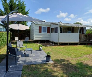 Terrasse et pelouse avec parasol et chaises du mobil-home 323 6 personnes 3 chambres