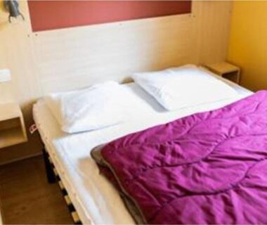 Intérieur chambre avec lit double et couette violette dans le Mobil-home 32m² API-1-52-1236